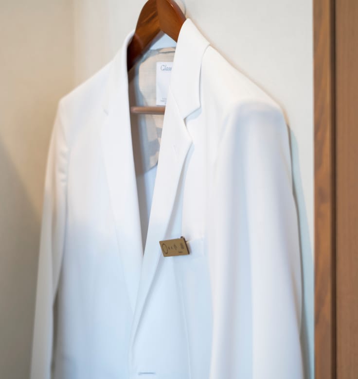 医師が使用する白衣をクローズアップし、清潔さと専門性を感じさせるビジュアル